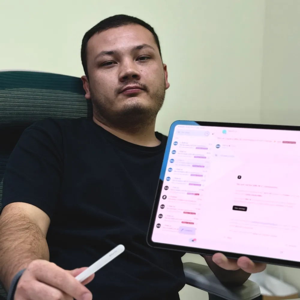 Jamik holding an iPad with commission emails from the Framer Marketplace